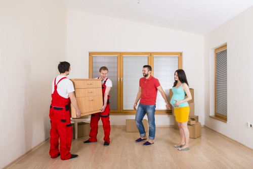Movers carrying furniture from a flat in Belsize Park